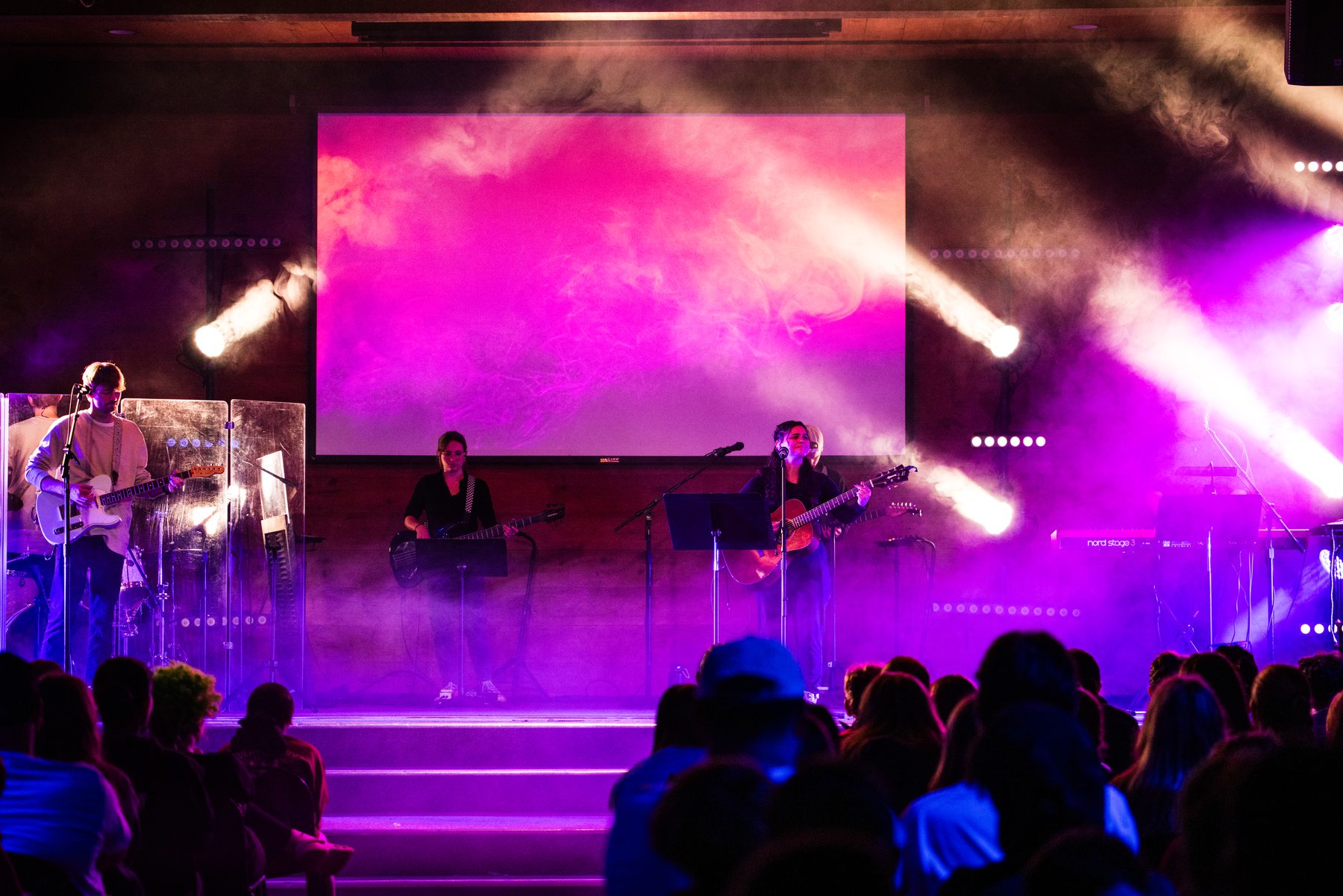Full stage in a saturated magenta look during a worship session
