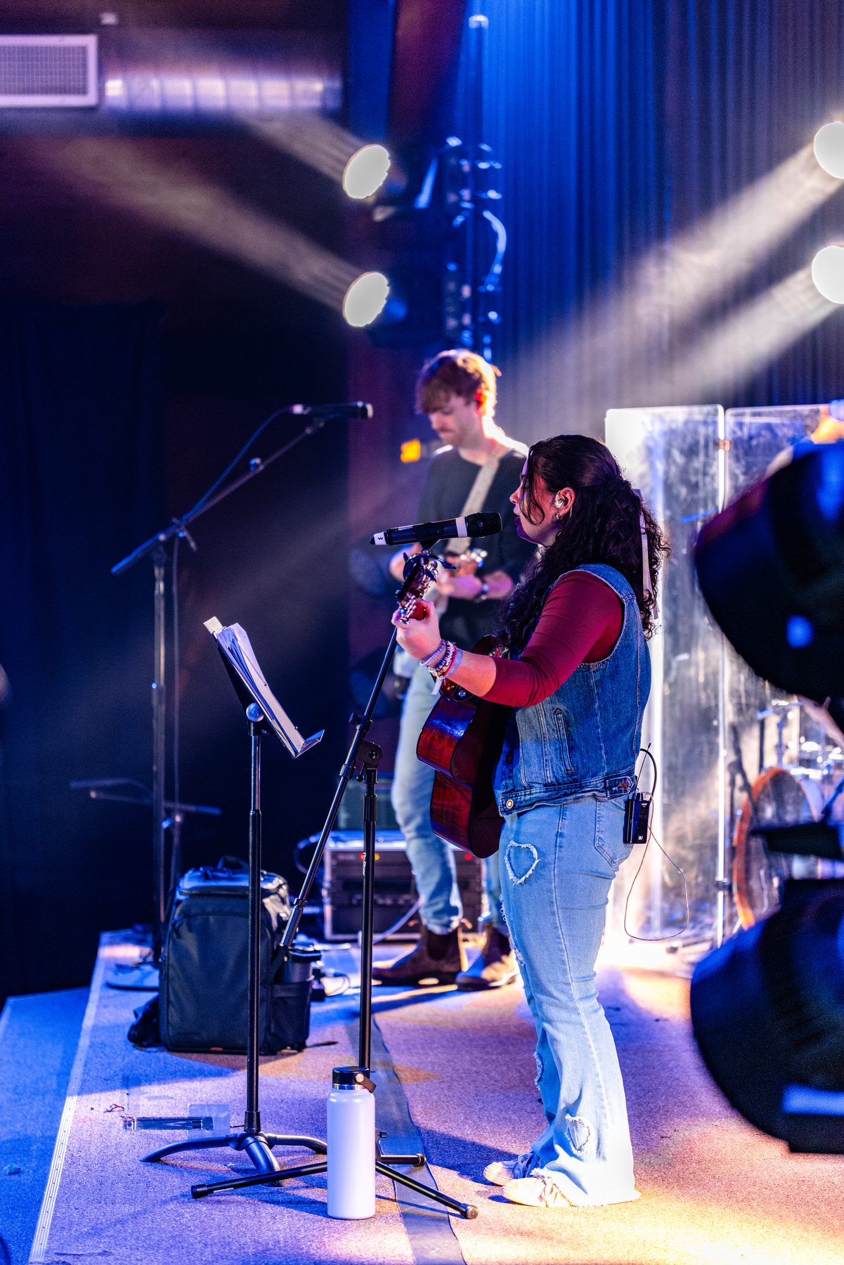Vocalists on stage under cool blue side light and back beams at CSM Fall Retreat