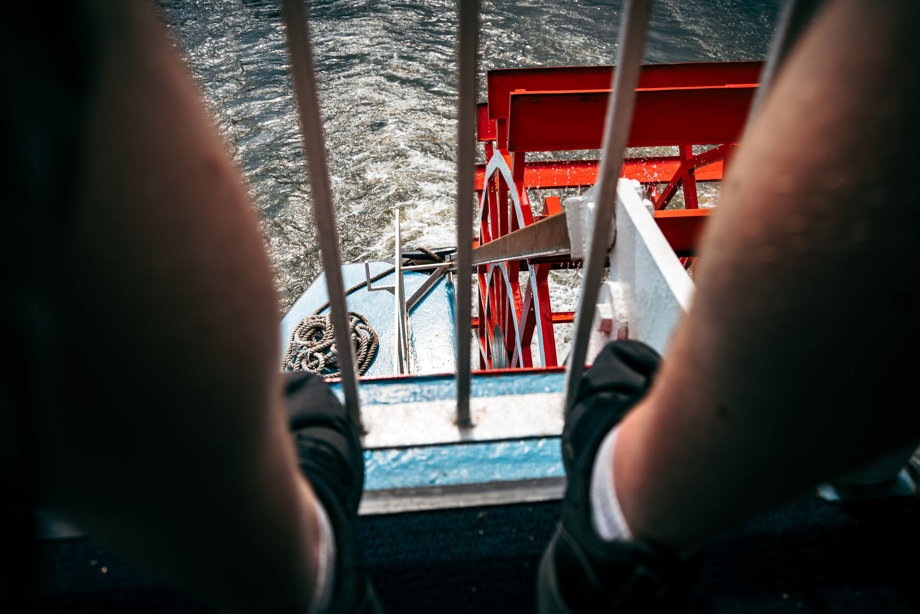 A candid moment aboard a Gateway Clipper river cruise, feet up on the rail beside the boat's red paddlewheel housing